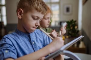 Close up of students writing notes in to their notepads.