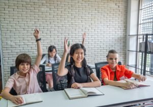 Elementary school students raise their hands to ask class teacher
