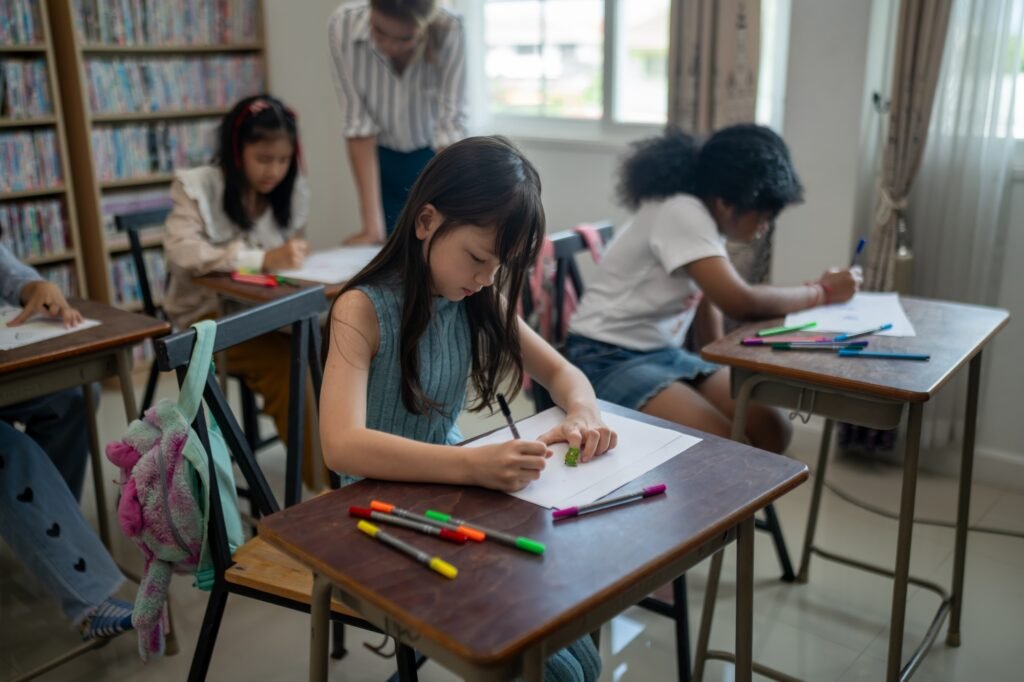 Group of student learn with teacher in classroom at elementary school.